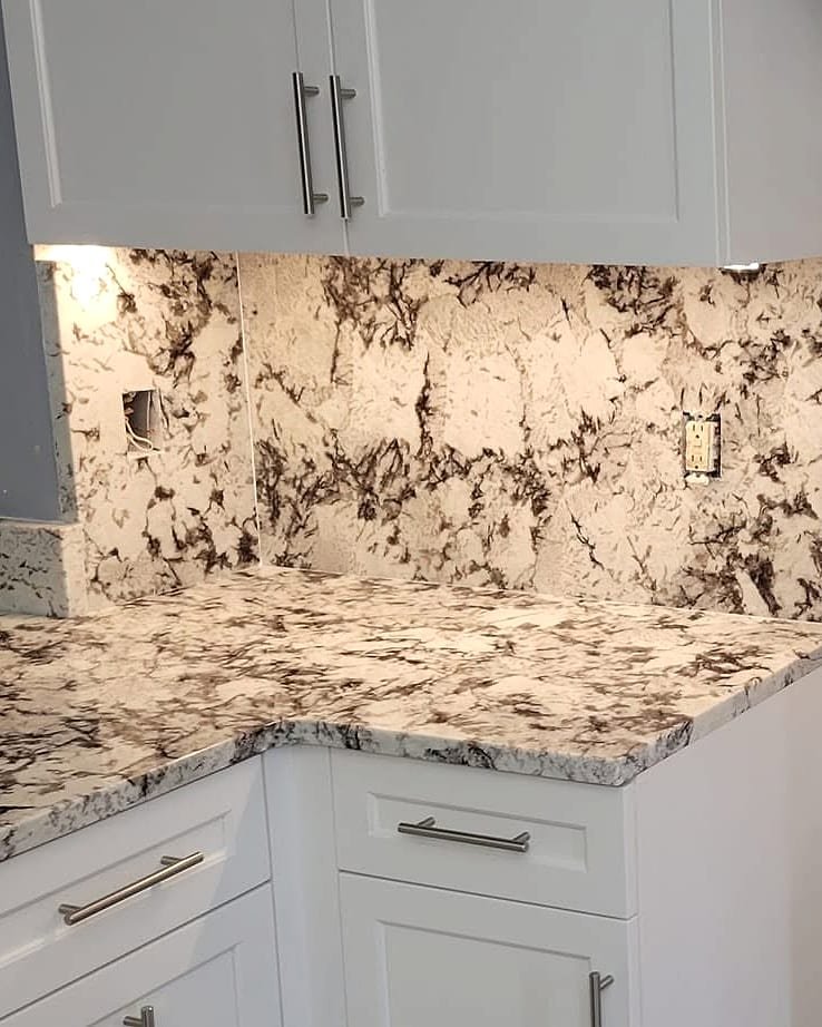 White and black granite countertops with a matching full-height granite backsplash installed by Fuzion Stone Surfaces