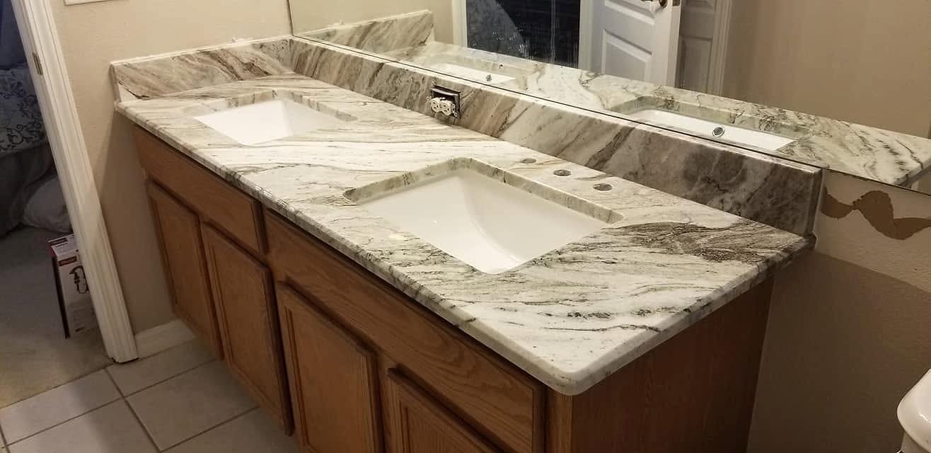 Double bathroom vanity with a marble top and two undermount sinks installed by Fuzion Stone Surfaces