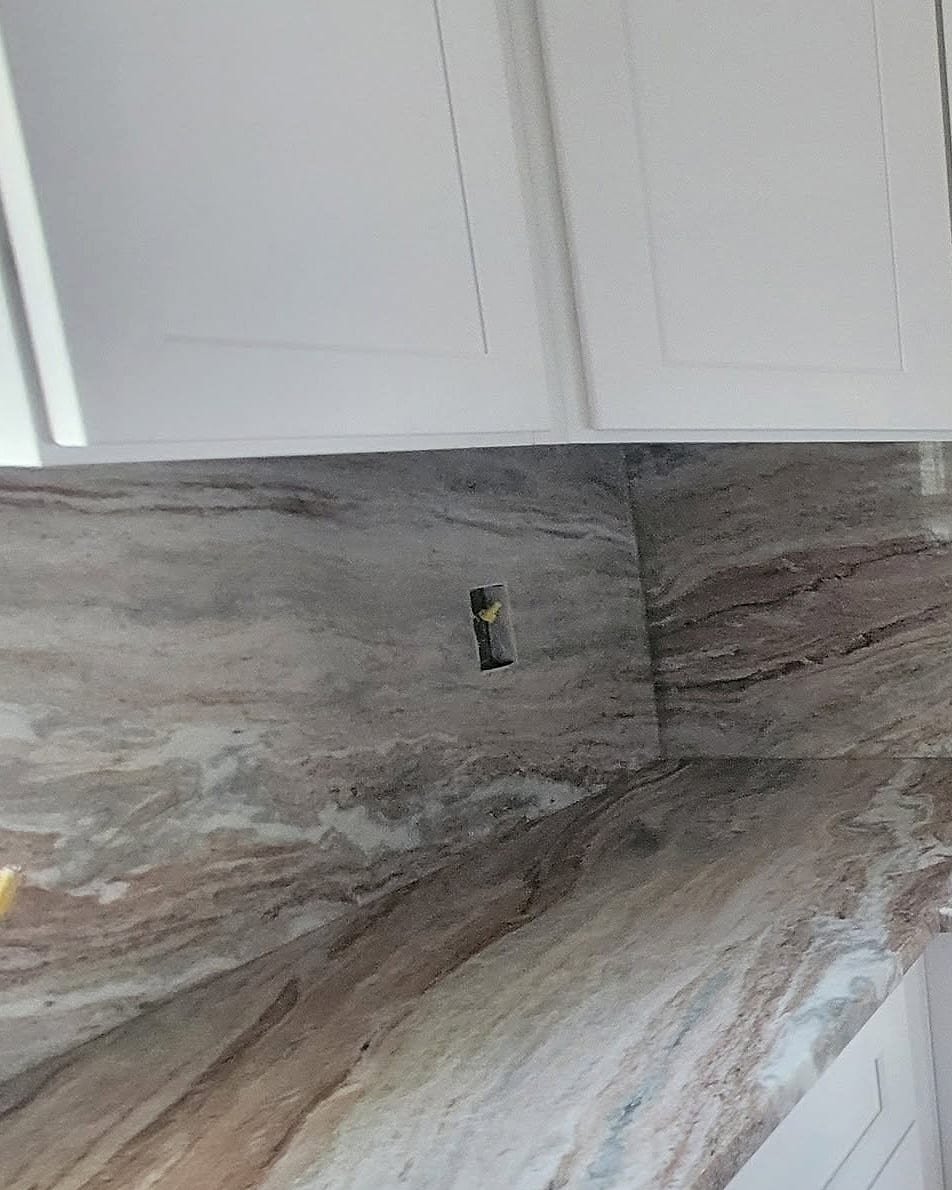 Marble countertop and matching marble backsplash installed by Fuzion Stone Surfaces under white shaker cabinets